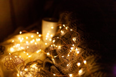 white lighted candle on silver holder